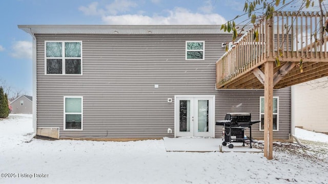 snow covered house featuring french doors