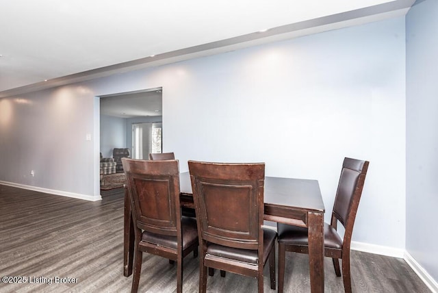 dining area featuring baseboards and dark wood-style flooring