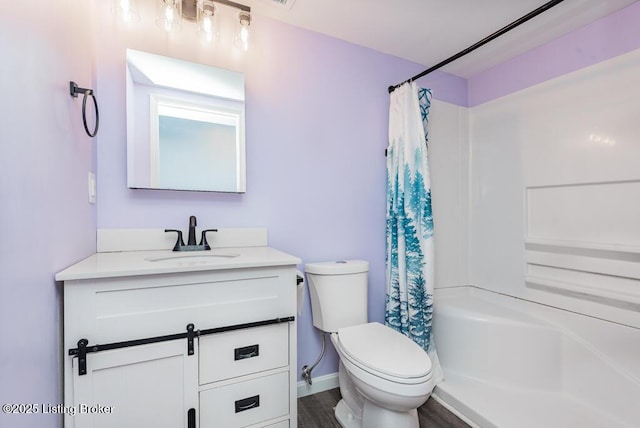 bathroom featuring baseboards, vanity, and toilet