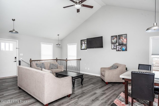 living room with high vaulted ceiling, baseboards, and wood finished floors