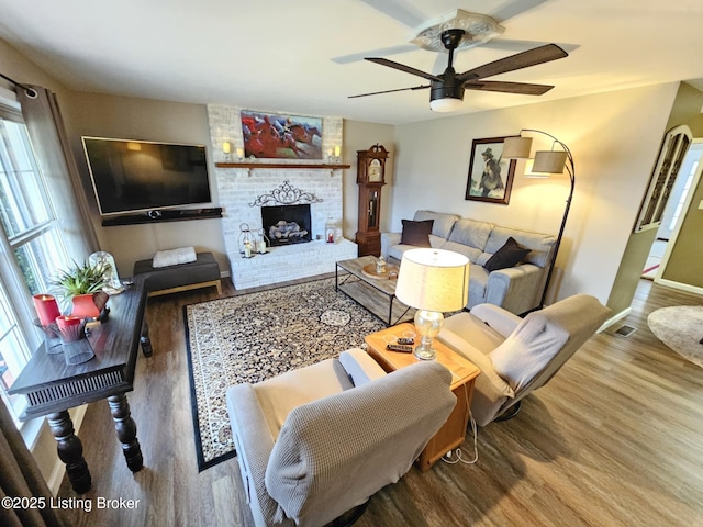 living room with ceiling fan, a fireplace, and hardwood / wood-style floors