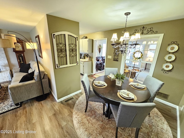 dining area featuring a notable chandelier and light wood-type flooring