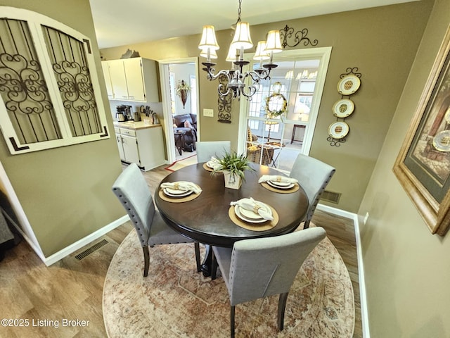 dining room with a notable chandelier and light wood-type flooring