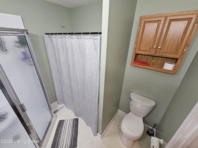 bathroom with tile patterned floors, toilet, and a shower with shower door