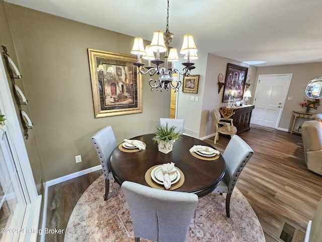 dining room featuring dark wood-type flooring and a chandelier