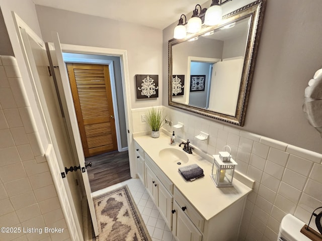 bathroom with tile patterned floors, vanity, and tile walls