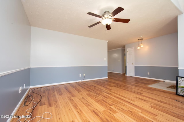 unfurnished living room featuring ceiling fan, light hardwood / wood-style flooring, and a textured ceiling