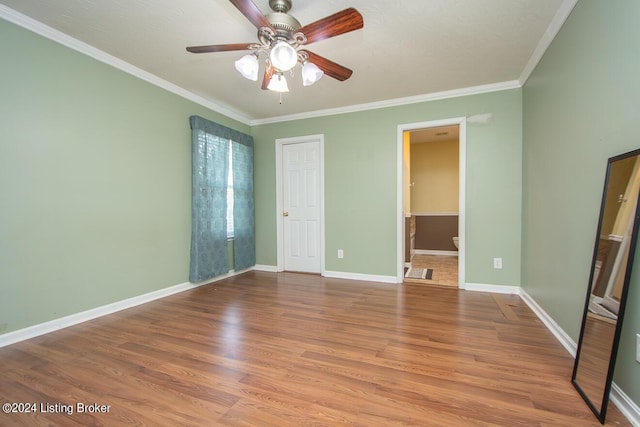 unfurnished bedroom featuring wood-type flooring, ornamental molding, ceiling fan, and ensuite bathroom