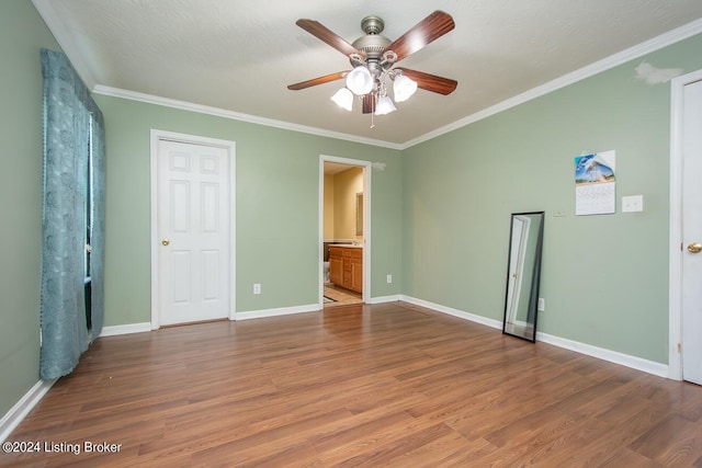 unfurnished bedroom with hardwood / wood-style flooring, ornamental molding, ceiling fan, and ensuite bathroom