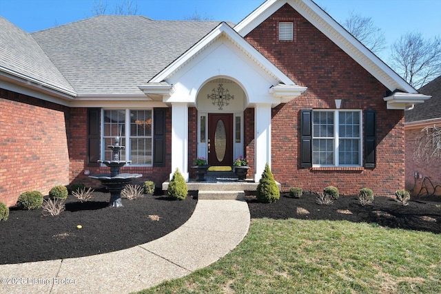 exterior space featuring a yard, brick siding, and roof with shingles