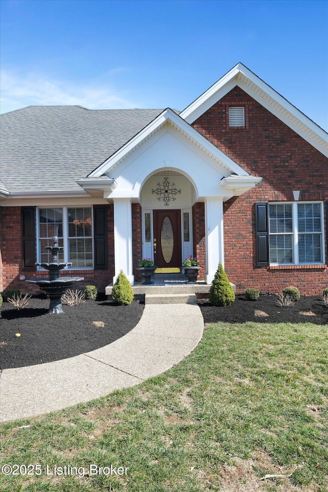 view of front of property featuring brick siding and a front yard