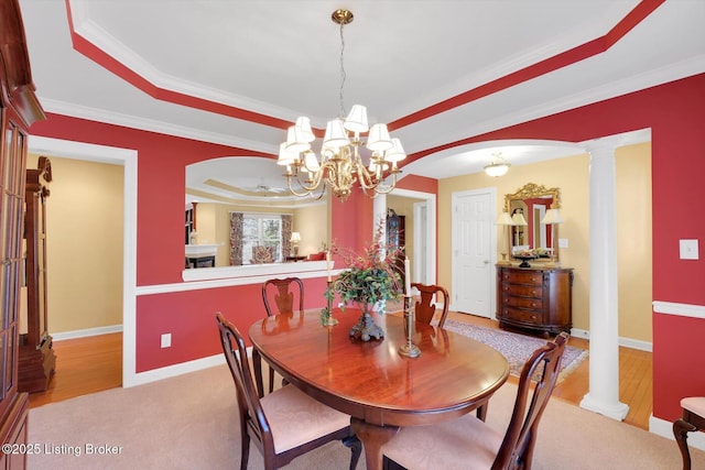 dining room with arched walkways, baseboards, a raised ceiling, and an inviting chandelier