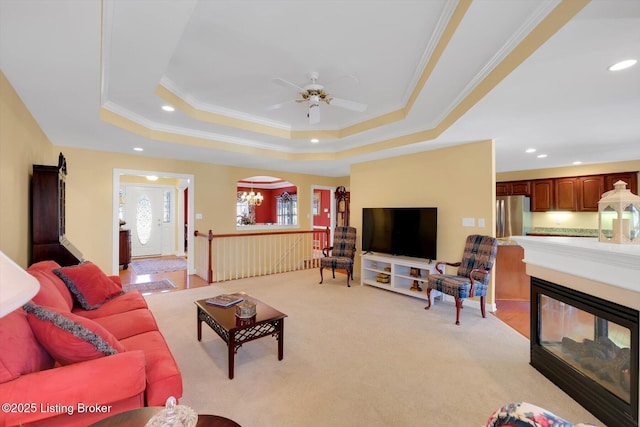 living room featuring ceiling fan, a tray ceiling, recessed lighting, and ornamental molding