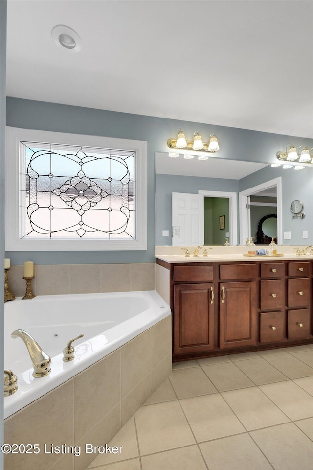 bathroom with tile patterned floors, a jetted tub, and vanity