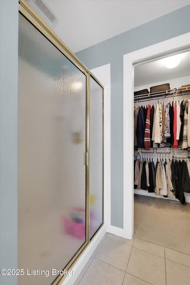 full bath with tile patterned floors, visible vents, a spacious closet, and a shower stall