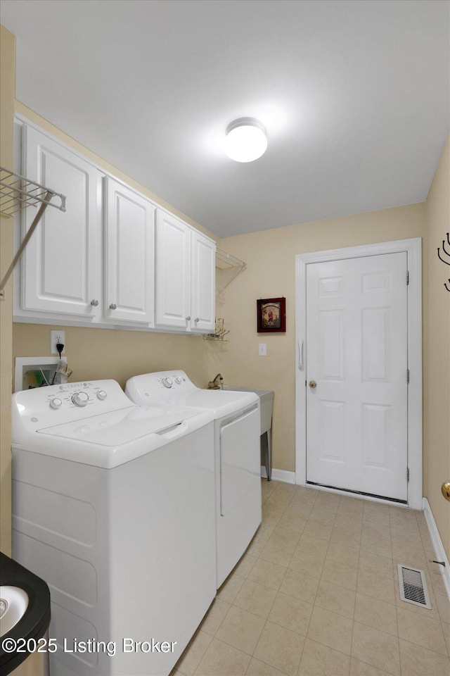 laundry room with baseboards, visible vents, washing machine and clothes dryer, cabinet space, and a sink