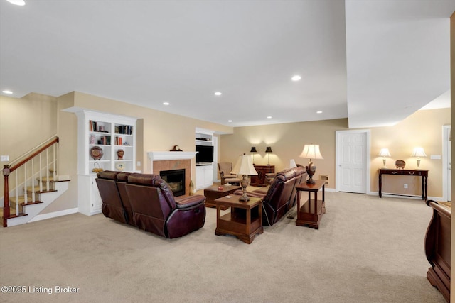 living area with stairway, recessed lighting, a tile fireplace, and light carpet