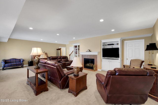 living area with recessed lighting, light colored carpet, and a tile fireplace