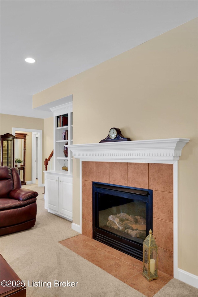 living area with built in shelves, a tiled fireplace, recessed lighting, baseboards, and light colored carpet