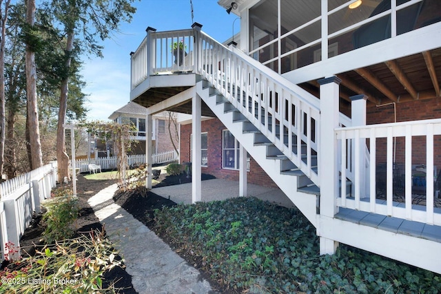 exterior space featuring stairs, a patio, fence, and a sunroom