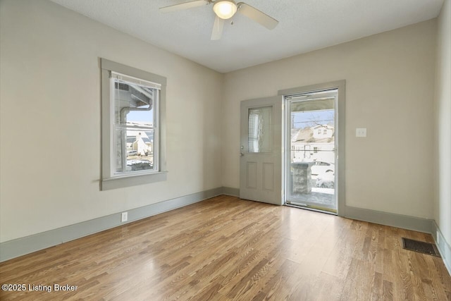 foyer with ceiling fan, light hardwood / wood-style flooring, and a textured ceiling