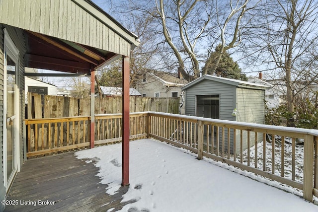 snow covered deck featuring a shed