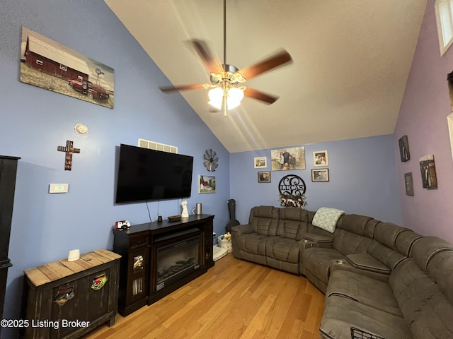 living room featuring vaulted ceiling, ceiling fan, and light hardwood / wood-style floors