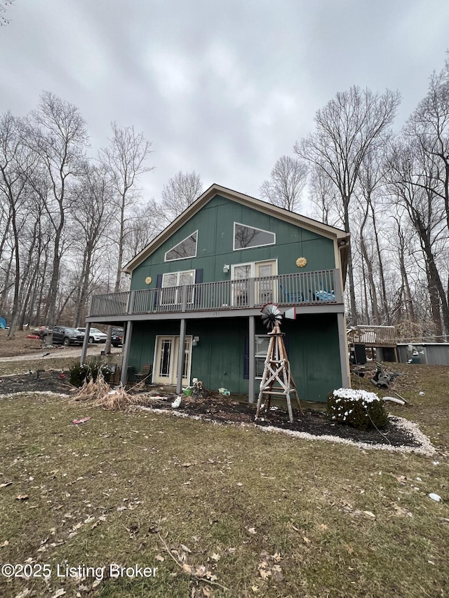 rear view of property with a deck and a lawn