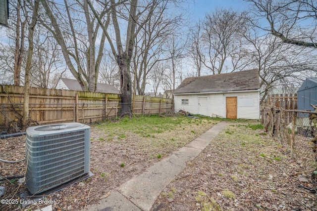 view of yard featuring a fenced backyard, central AC, and an outdoor structure