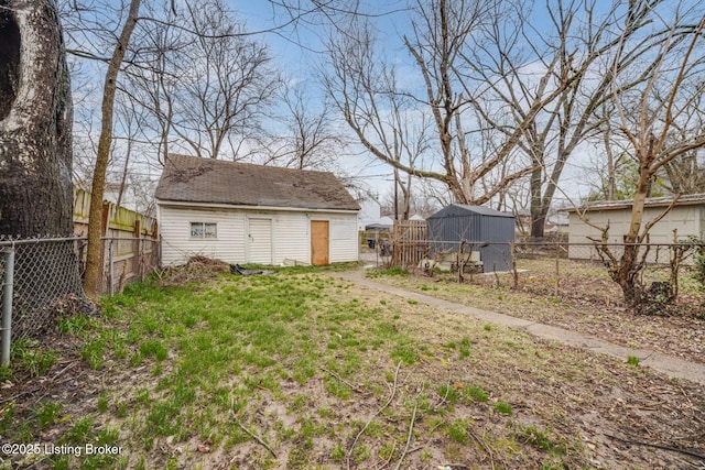 view of yard with an outbuilding, a fenced backyard, and a storage unit