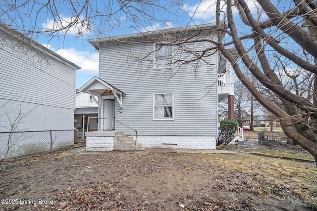 back of house with crawl space and fence