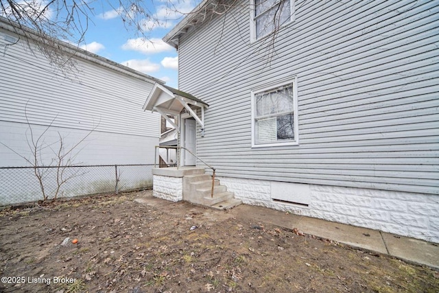 view of property exterior with crawl space and fence