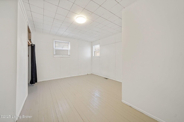 spare room featuring baseboards and hardwood / wood-style floors