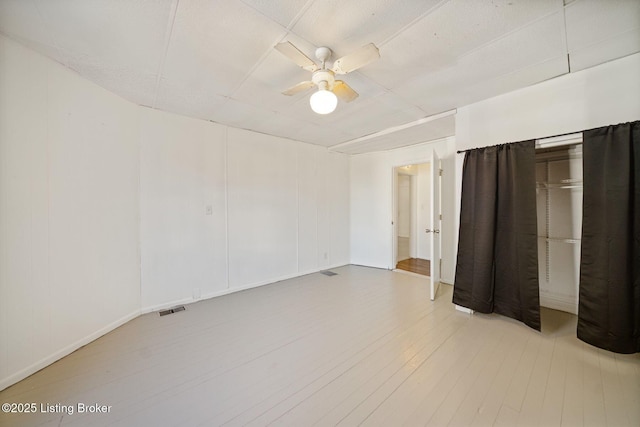unfurnished bedroom featuring light wood-style floors, visible vents, and a ceiling fan