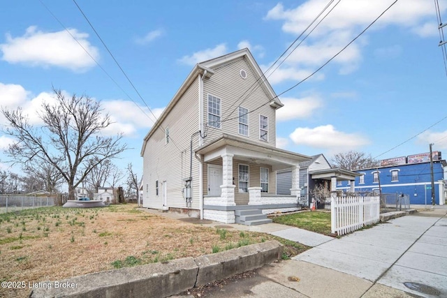 view of front of house featuring a front yard, covered porch, and fence