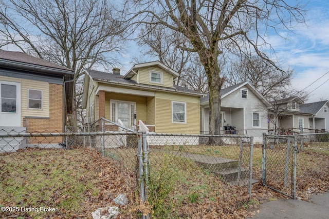 bungalow-style home featuring a fenced front yard, a gate, and a chimney