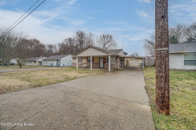 view of front of property featuring brick siding, a porch, a front yard, a garage, and driveway