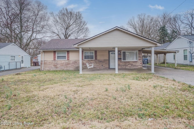 view of front of home featuring a carport, stone siding, driveway, and a front lawn