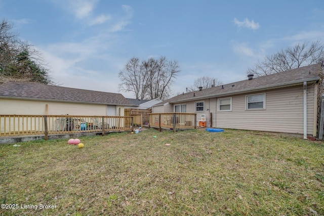 rear view of property with a deck and a yard