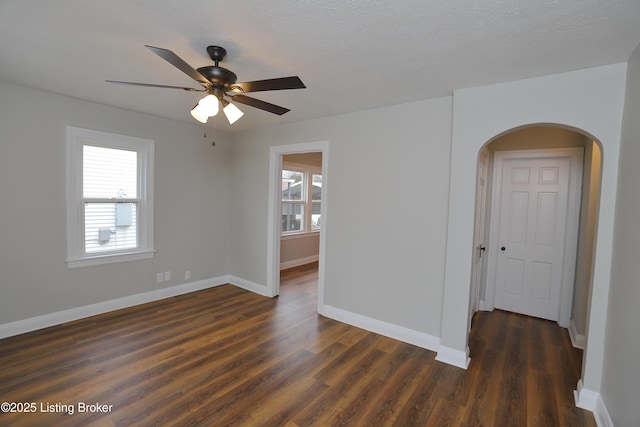 empty room with ceiling fan and dark hardwood / wood-style floors