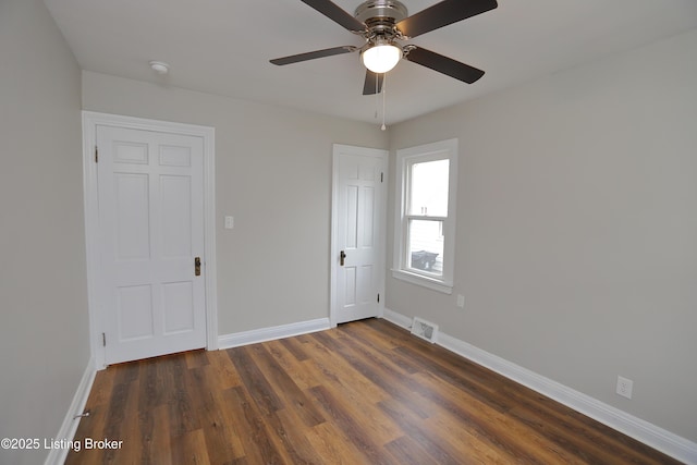 empty room featuring ceiling fan and dark hardwood / wood-style floors