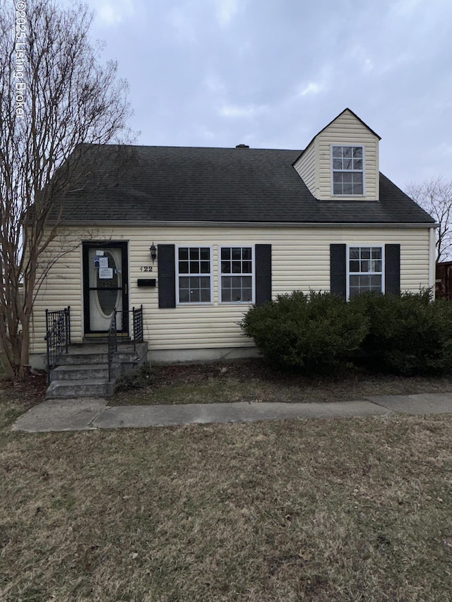 view of front facade featuring a shingled roof and a front lawn