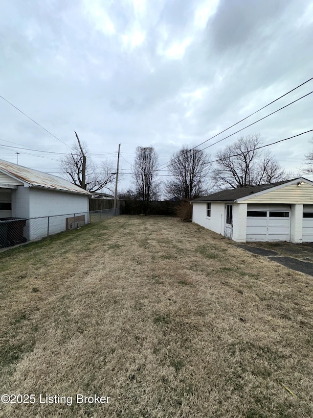 view of yard featuring a detached garage and fence