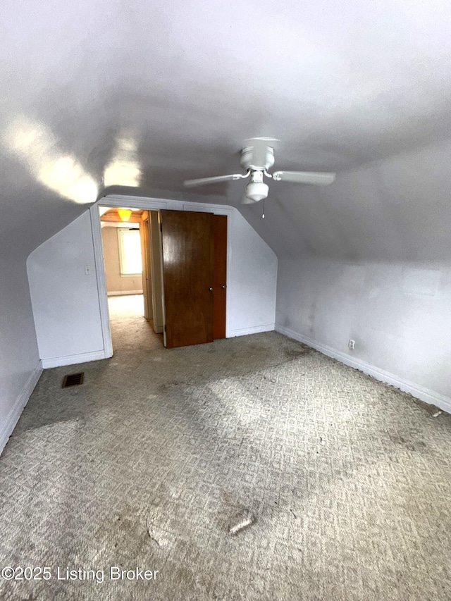 bonus room featuring lofted ceiling, visible vents, a ceiling fan, carpet flooring, and baseboards