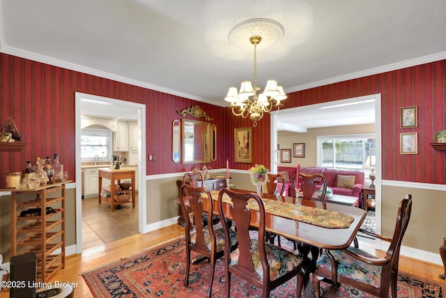 dining space with hardwood / wood-style floors, a chandelier, sink, and ornamental molding