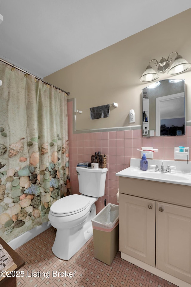 bathroom featuring a shower with curtain, vanity, tile walls, and toilet