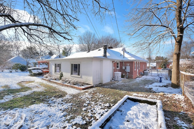 snow covered property featuring central AC unit