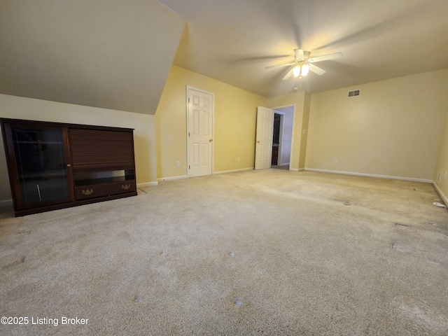 bonus room with ceiling fan and light colored carpet