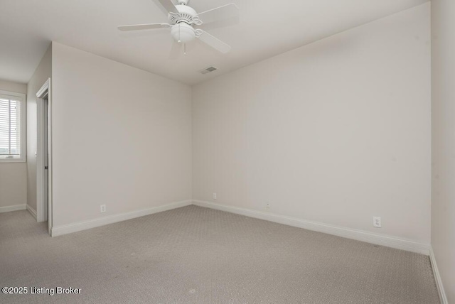 empty room with light carpet, ceiling fan, visible vents, and baseboards