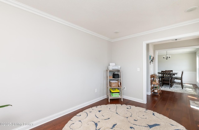 living area featuring an inviting chandelier, crown molding, baseboards, and dark wood-type flooring